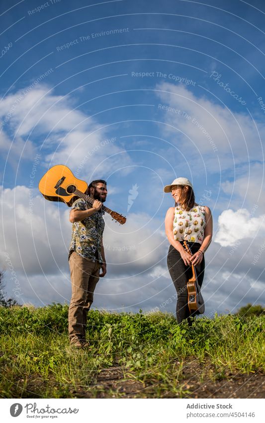 Musikanten stehen auf grünem Gras gegen blauen Himmel in sonnigen Tag Mann Frau Gitarre akustisch Instrument Musiker Ukulele Natur spielen männlich Sommer