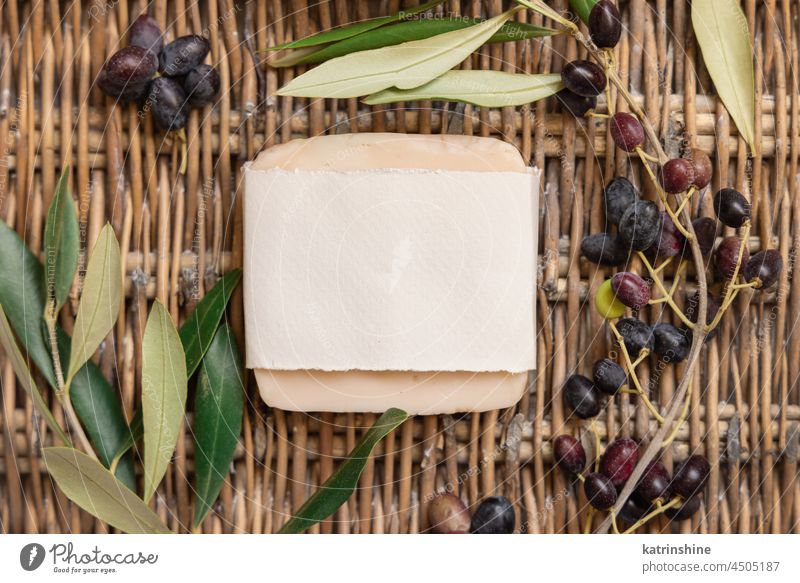 Seifenbar auf einem Tisch mit Olivenzweigen als Attrappe handgefertigt Bar oliv Ast blanko geknattert Draufsicht Papier hölzern beige Schwimmhäute Konzept weiß