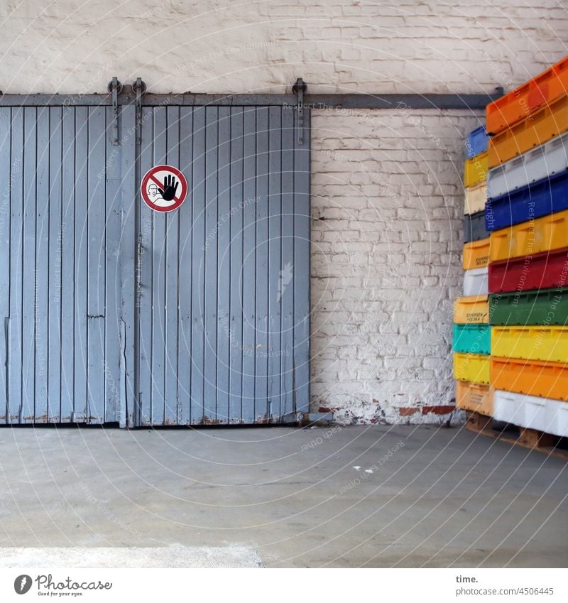 closed today • blaues Schiebetor mit Betretungsverbotschild neben bunten Fischkisten auf Holzpalette vor weißgetünchter Backsteinwand Lagerhalle fischkisten