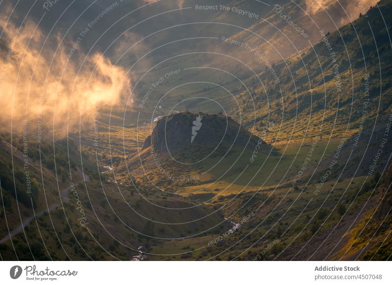 Grasbewachsenes Tal mit Wolken im Sonnenlicht Hügel Natur Nebel Berghang Hügelseite Feld Landschaft Dunst Umwelt wild Örtlichkeit natürlich steil malerisch