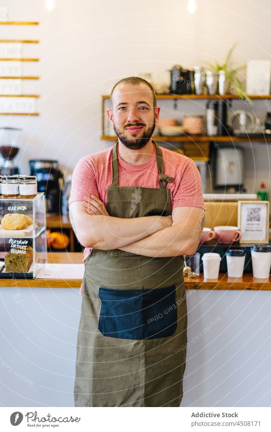 Gut gelaunter Barista am Tresen Mann Kaffeehaus Abfertigungsschalter Arbeit Dienst Personal Arbeitsplatz Vorrichtung Beruf Vorrat professionell Schürze männlich