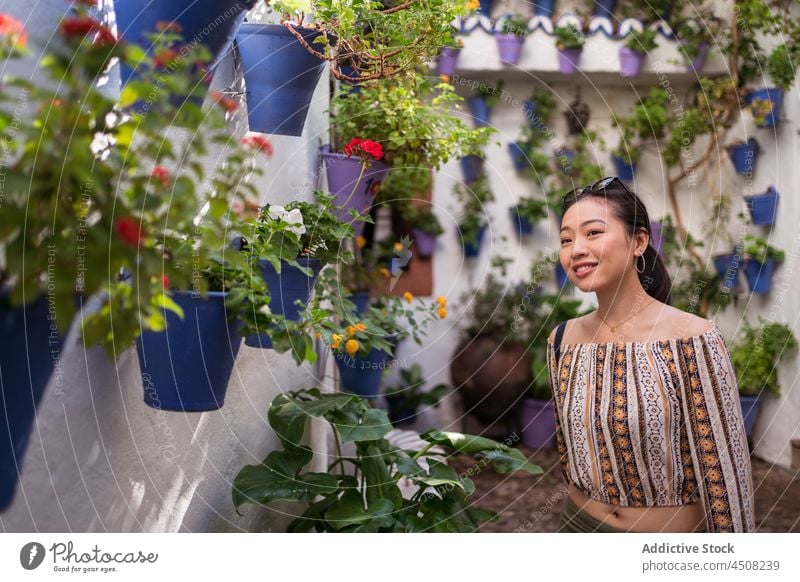 Asiatische Frau steht in der Nähe von Topfblumen Gebäude Blume Pflanze Straße Blumentopf Dekor Flora Stadt Tourist geblümt Blüte farbenfroh Wachstum natürlich