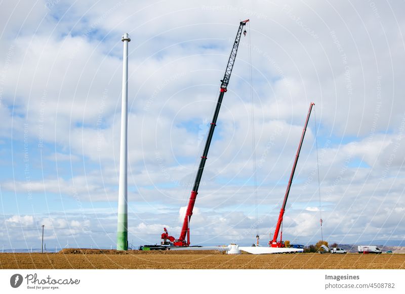 Deinstallation der alten Windkraftanlage. Am Boden liegende Blätter eines Windgenerators und Kräne. Ackerland mit Bauarbeiten am Windpark. Wörrstadt, Deutschland