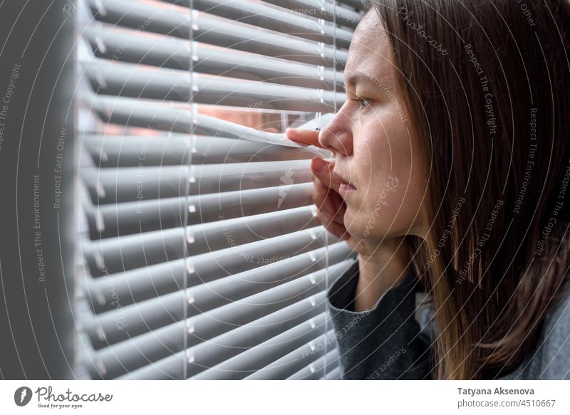 Besorgte Frau schaut zum Fenster Anspannung Einsamkeit Depression unglücklich Verzweiflung beunruhigt Leiden frustriert deprimiert einsam eine Person heimwärts