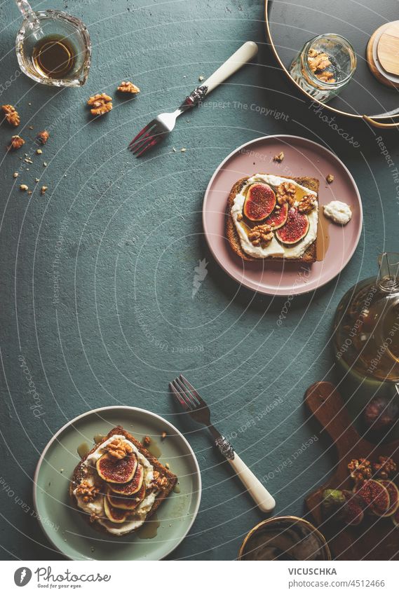 Leckeres Frühstück mit French Toast mit Schlagsahne, geschnittenen Feigen und Nüssen auf Beton Küchentisch mit Gabeln und Schalen. Draufsicht mit Kopierbereich.