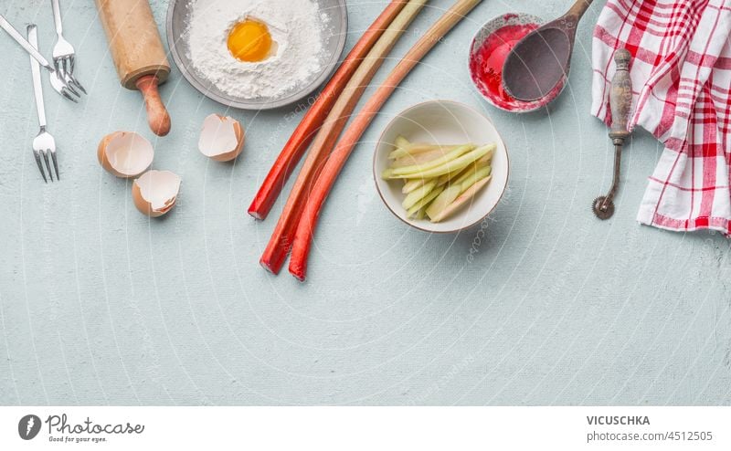 Zubereitung zum Backen mit Rhabarber. Vorbereitung Eigelb Mehl Eierschale hölzern Nudelholz Gabeln Licht Küchentisch Draufsicht Textfreiraum Hintergrund backen