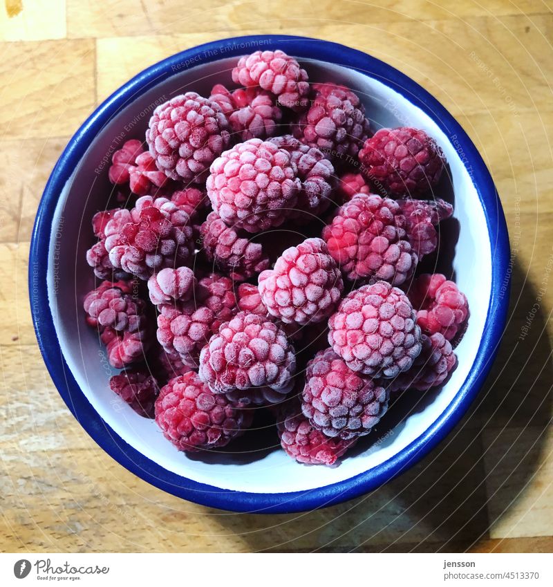 gefrorene Himbeeren in einer weiß-blauen Emailleschale Frucht Lebensmittel Gesundheit Ernährung rot frisch Beeren lecker Nahaufnahme Farbfoto süß