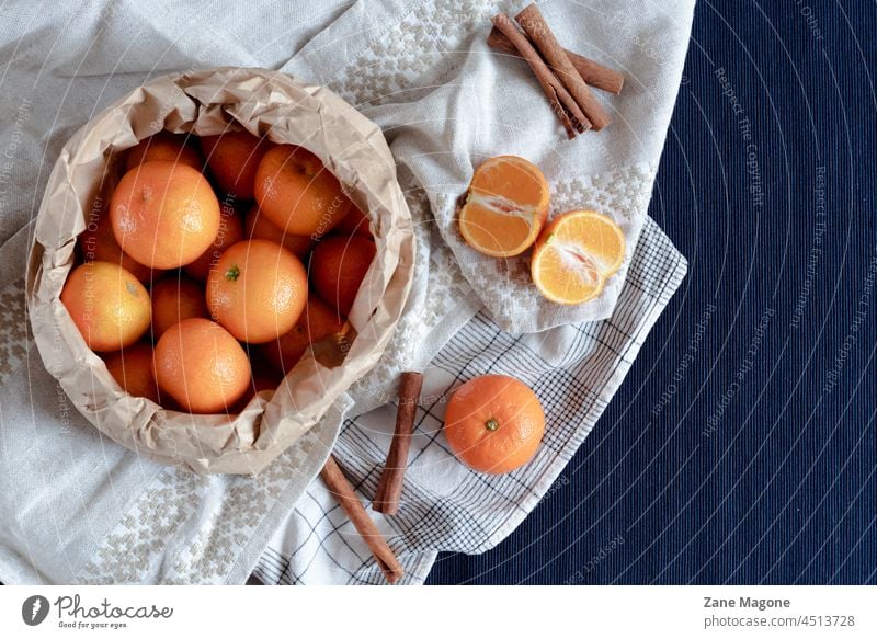 Mandarine Früchte und Zimtstangen gestylt auf blauem Tuch Hintergrund, flach legen, Winter-Thema Mandarinen fallen Weihnachten Weihnachten & Advent Frucht