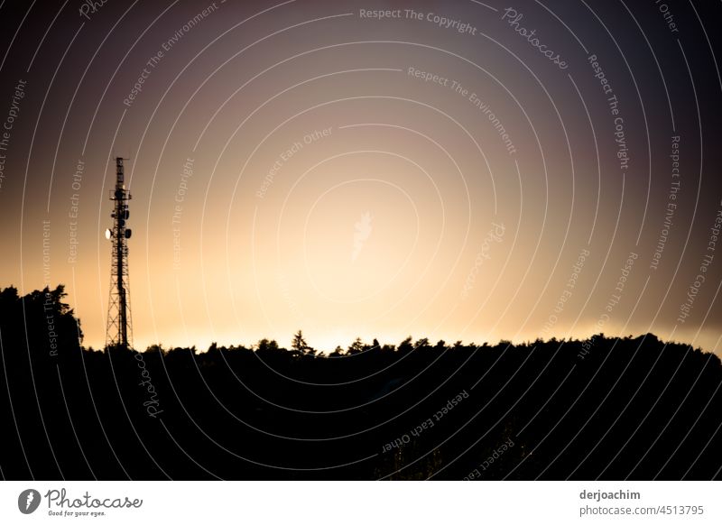 Ein heller Silhouette  Schein , hinter dem Hintergrund mit der daneben stehenden Großen Antenne. Der  Sonnenuntergang hat eingesetzt und taucht das Land in einen hellen Lichtschein.