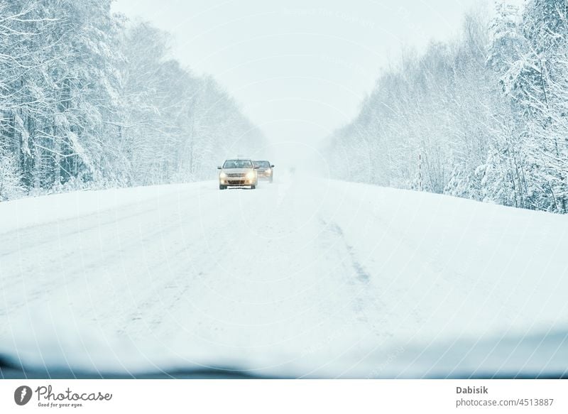 Verschneite Straße im Winterwald mit fahrendem Auto PKW Wetter verschneite Verkehr Schnee Eis im Freien Wald Frost Fahrzeug Automobil Schneesturm Bremse kalt