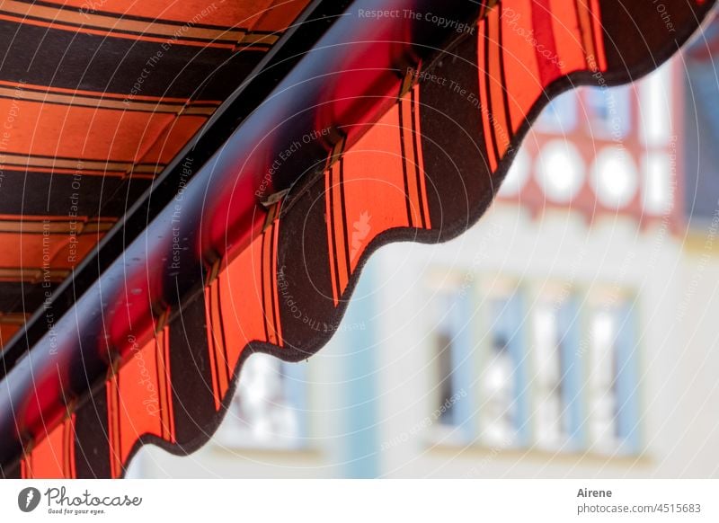 Schatten oder Sonne? Markise Kontrast Sommer rot schwarz gestreift Streifen schräg diagonal Sonnenschutz Schattenspender Jalousie Sonnenlicht Fenster gegenüber