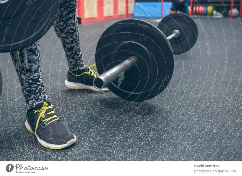 Hantel neben unkenntlichen Sportlerbeinen Curl-Hantel Kurzhantel Gewichtheben Scheiben Bar Mann Beine Bodybuilder Gerät Körper Heben Fitnessstudio Athlet