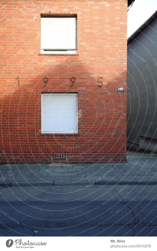 1995 Fenster Rolladen Straße Bürgersteig Fassade Gehweg Haus Architektur geschlossen trist Stadtrand Kleinstadt Einfamilienhaus Gebäude Altbau Schattenwurf Dorf