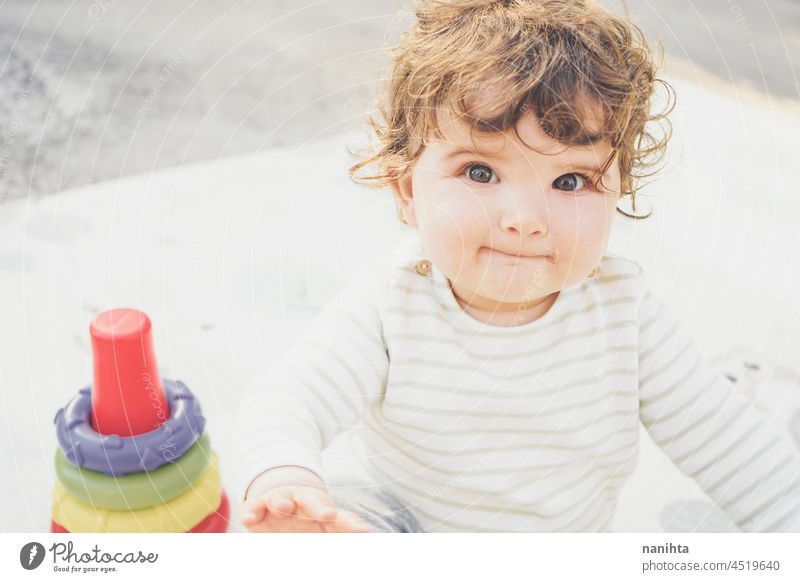 Kleines Baby genießt den Tag beim Spielen mit ihrem Spielzeug spielerisch Säuglingsalter Elternschaft Kleinkind Glück Fröhlichkeit genießen Kindergarten