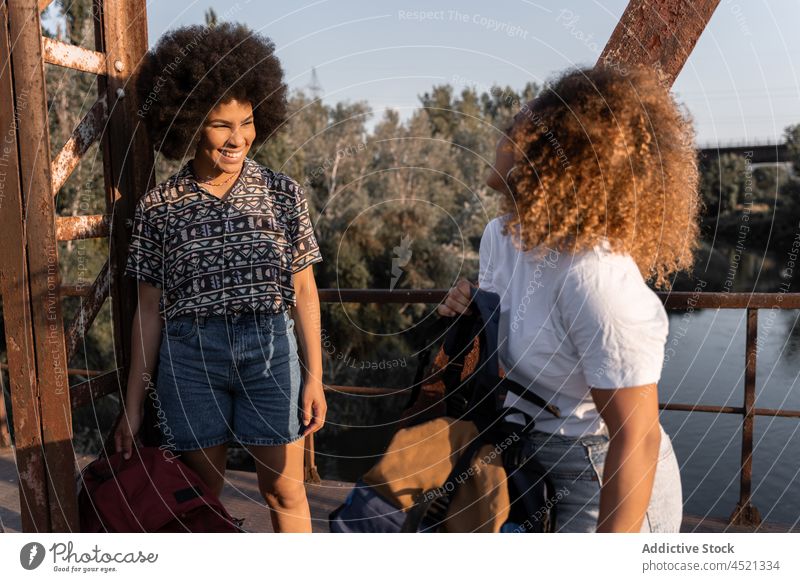 Schwarze Frauen, die während einer Wanderung auf einer Brücke Halt machen Freund Wanderer Pause Stillstand verwittert Erholung positiv Abenteuer ruhen schäbig