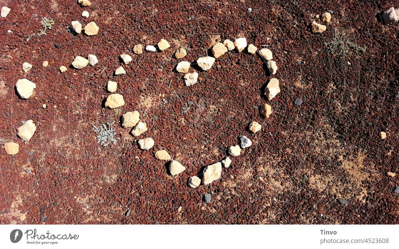 Herz aus Steinen geformt auf roter Lava Lavagranulat Granulat Natur herzförmig Symbole & Metaphern Romantik Farbfoto Zeichen Außenaufnahme Verliebtheit Gefühle