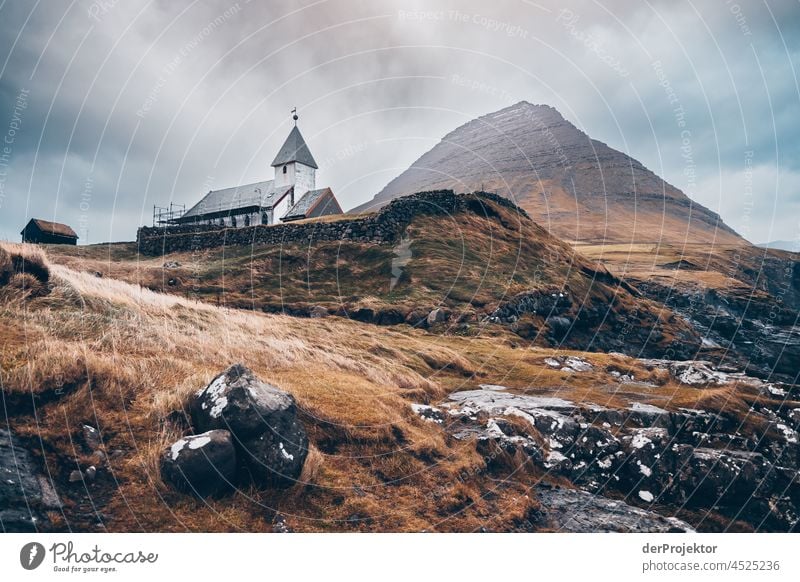 Felsen mit Kirche in Viðareiði auf den Färöer Inseln Brandung schroff Berghang Gelände Sonne abweisend kalte jahreszeit Dänemark Naturerlebnis Abenteuer