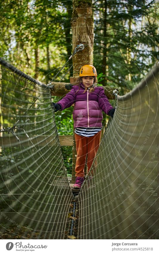 Abenteuerkletterpark Hochseilgarten - Kinder im Parcours mit Helm und Sicherheitsausrüstung Klettern Park Schutzhelm hoch Gerät Menschen jung Aktion Freizeit