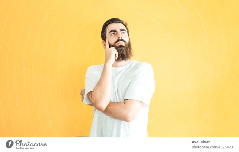 Junge Hipster bärtigen Mann ernstes Denken Position, Leerzeichen, Kopie Raum, weichen gelben abnehmbaren Hintergrund, minimale grundlegende, Ad-Konzept Deal, weißes Hemd Raum