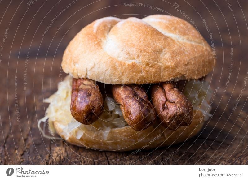 Nürnberger Würstchen mit Sauerkraut im Brötchen Bratwurst Wurst Fleisch Bayern Essen Sandwich Brot Grill Schweinefleisch Senf gegrillt Hot Dog gebraten imBiss