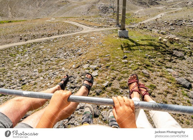 Eine Familie in einer Seilbahn genießt die Aussicht und die Schafe im Nationalpark Sierra Nevada, Spanien Berge Landschaft Textfreiraum