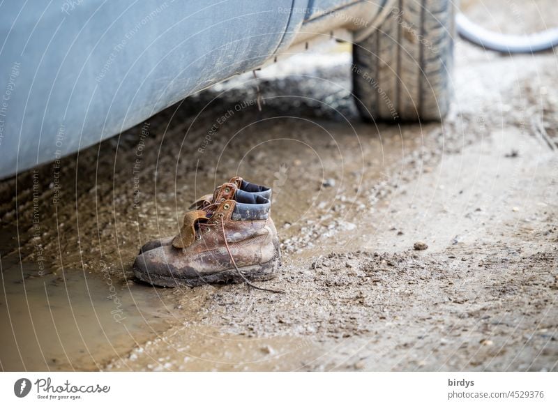 Leichtigkeit |endlich raus aus den Kloben. Verdreckte Wanderschuhe im Matsch dreckig Schlamm Auto Wandern Pfütze nass Schuhe Wanderstiefel abgestellt ausgezogen