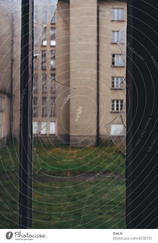 Ausblick aus zerbrochenem Fenster Scheibe defekt kaputt Scherben Gebäude marode alt gruselig