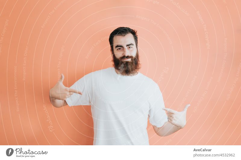 Junge Hipster bärtigen Mann Blick weg von der Kamera, Kopie Raum, weiche orange abnehmbarem Hintergrund, minimal basic, Ad-Konzept Deal, weißes Hemd Raum