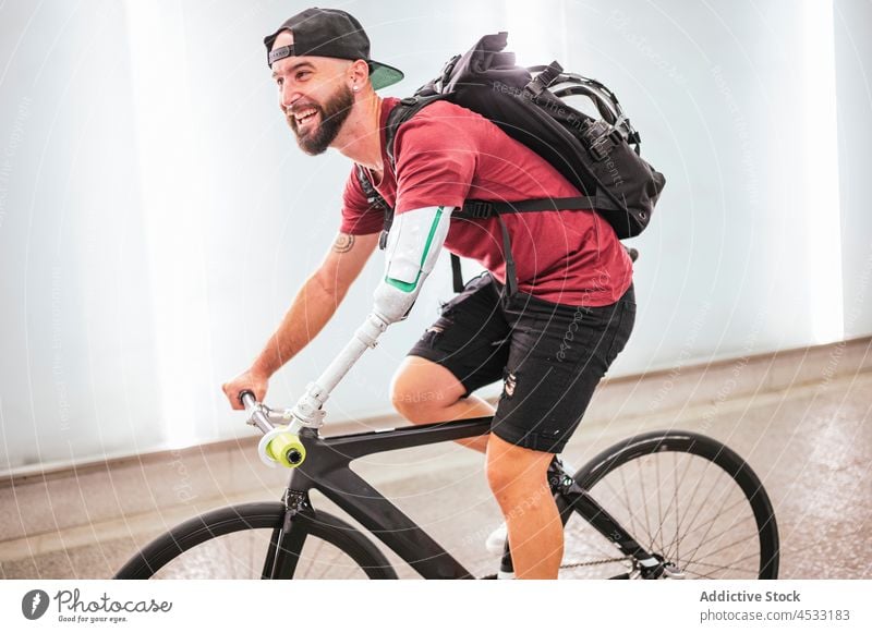 Mann mit bionischem Arm fährt Fahrrad in der Stadt künstlich Arme Prothesen Handicap Prothetik Mitfahrgelegenheit Großstadt Bionik männlich Straße Radfahrer