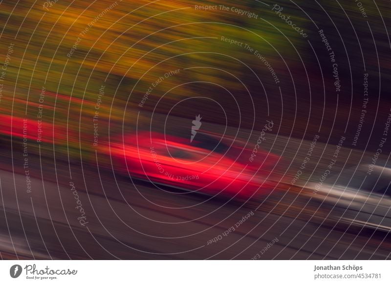 rotes Auto mit Bewegungsunschärfe auf Straße aus Vogelperspektive parken autoverkehr Umweltverschmutzung Tempo tempolimit Sportwagen Verkehr PKW Straßenverkehr