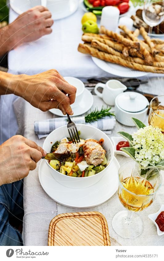 Ein festliches Familienessen oder Barbecue im Sommergarten. Familie Freizeit und Feier und Essen Konzept. Menschen essen bei einer Gartenparty. Grillen, Gemüse, Wein und Snacks. Das Leben in den Vorstädten