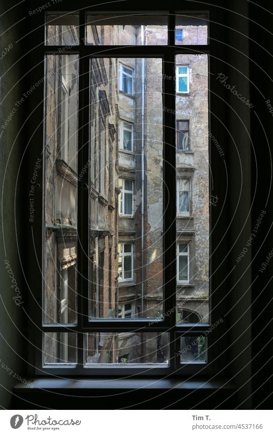 Blick durch ein Treppenhausfenster auf einen alten  Hof Berlin Fenster Hinterhof treppenhausfenster Altbau Haus Stadt Menschenleer Stadtzentrum Fassade Gebäude