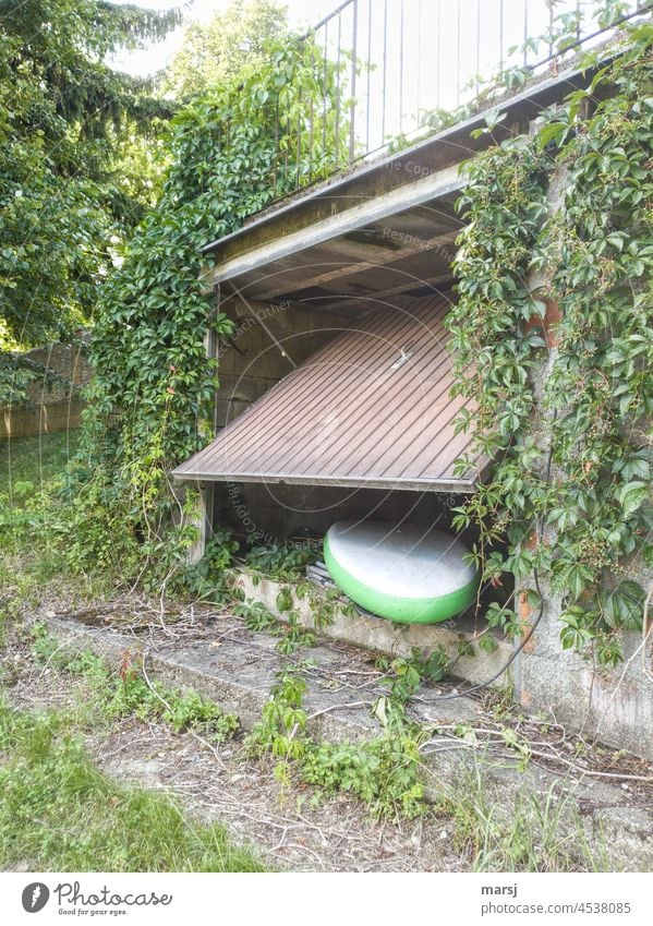 Die Garage kriegt vor lauter Gier die Klappe nicht mehr zu. Das grün-weiße SUP, Stand UP Paddle, hat in der vollen Garage keinen Platz. Garagentor