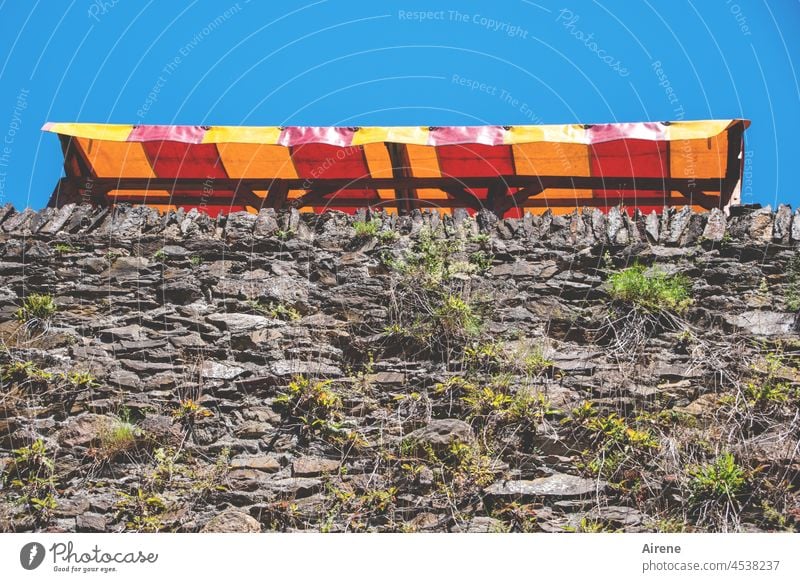 Beschattung der Mauerblümchen Markise Schattenspender Sonnenschutz Bruchsteinmauer Himmel strahlend blau Grundfarben kräftig farbig bunt sonnig warm heiß Sommer