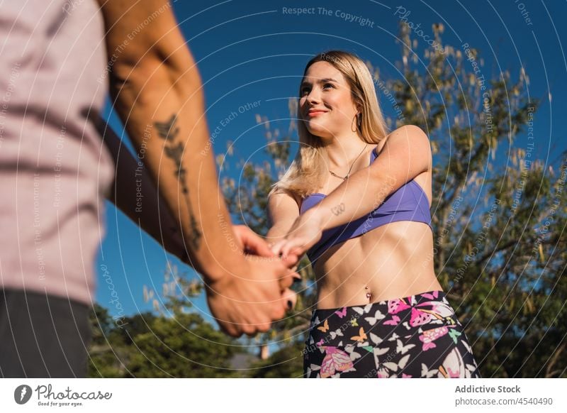 Junge Frau mit Freund in der Natur Paar Händchenhalten Freundin Zusammensein Zuneigung Park Liebe Sommer romantisch Partnerschaft Sportbekleidung Bonden stehen