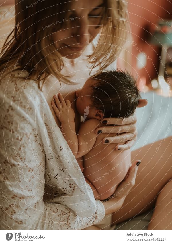 Junge Mutter mit nacktem Baby auf dem Bett liegend nach dem Stillen Frau neugeboren stillen Windstille Liebe Augen geschlossen niedlich Pflege Säuglingsalter