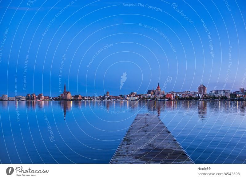 Blick über die Warnow auf die Hansestadt Rostock zur Blauen Stunde Fluss Stadthafen Mecklenburg-Vorpommern Kirche Petrikirche Blaue Stunde Steg Anlegestelle