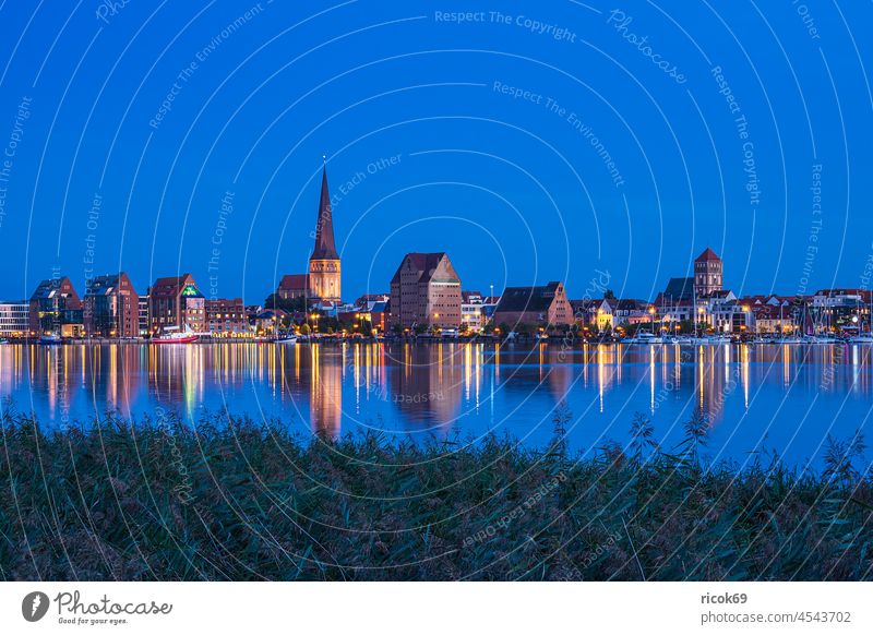 Blick über die Warnow auf die Hansestadt Rostock zur Blauen Stunde Fluss Stadthafen Mecklenburg-Vorpommern Kirche Petrikirche Blaue Stunde Schilf Herbst Baum