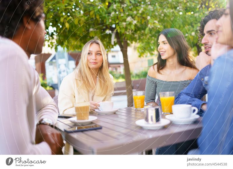 Multiethnische Gruppe von Studenten bei einem Drink auf der Terrasse einer Straßenbar. Menschen multiethnisch Menschengruppe Vielfalt Freunde Freundschaft