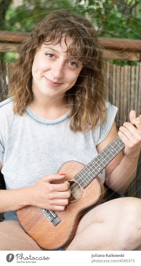 Frau spielt Ukulele im Garten üben gemütlich live musizieren Lied feminin Mädchen schön Künstlerisch Künstlerin Musikerin Coolness Artist sitzen Jugendliche