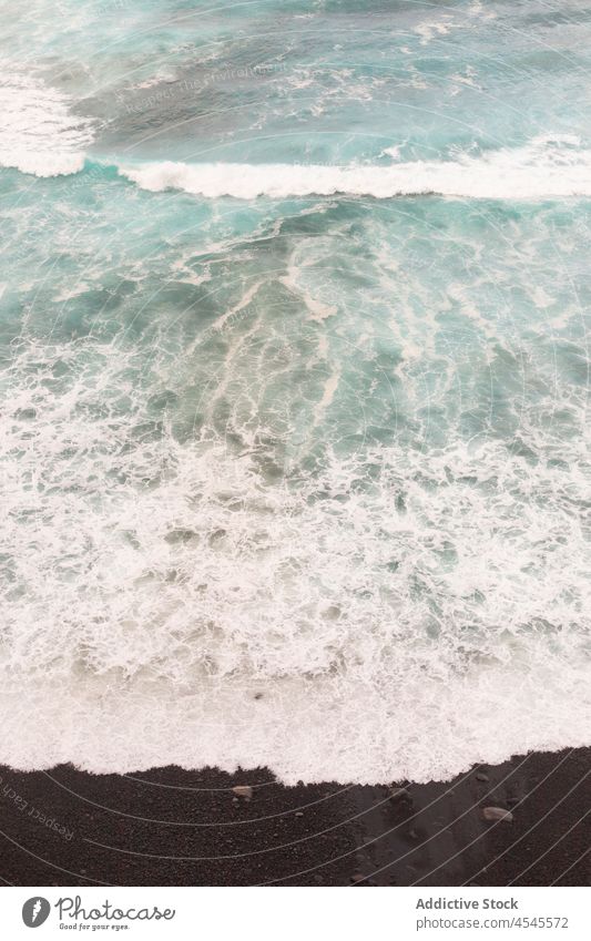 Schaumiges Meer auf dunklem Sand MEER winken schäumen Ufer Wasser Küste Natur Küstenstreifen Seeküste Strand Meeresufer Küstenlinie Gezeiten schwarz