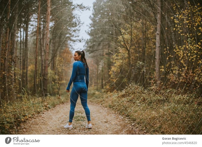 Junge Frau macht eine Pause beim Sport im Freien auf einem Waldweg im Herbst ruhen aussruhen Aktivität Erwachsener Athlet sportlich attraktiv blau Kaukasier