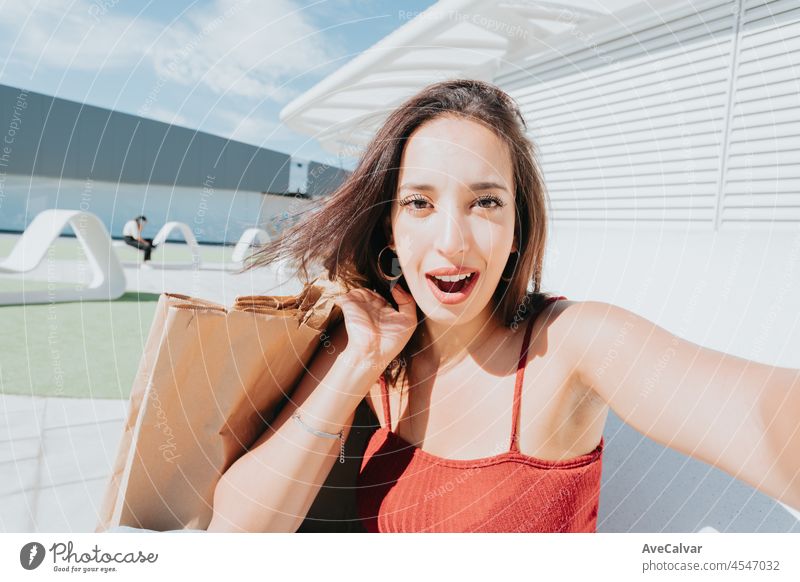 Selfie, Lifestyle-Konzept. Close up von jungen afrikanischen charmanten lockiges Haar Frau in roten T-Shirt lächelnd mit Zähnen, wobei selfie, im Chat mit Freund am Telefon.