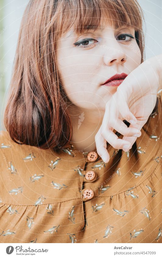 Moderne ernste Pose Porträt sie ihre Hipster Rothaarige junge Frau. Kopieren Sie Raum für Text Bild. Casual Dressing in herbstlichen Tönen. rote Lippen und moderne Frisur, hellen Tag. Körper positiv