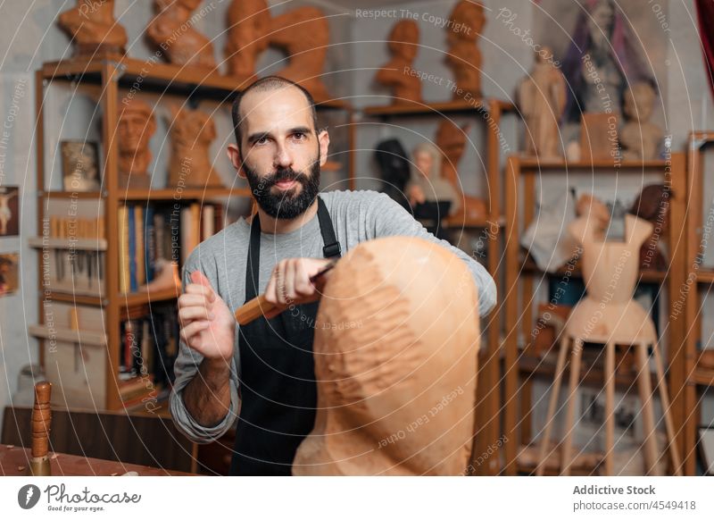 Konzentrierter Handwerker, der mit einem Meißel ein hölzernes Detail formt Zimmerer Beitel Form Holz Tischlerarbeit Werkstatt Handarbeit Holzarbeiten Instrument