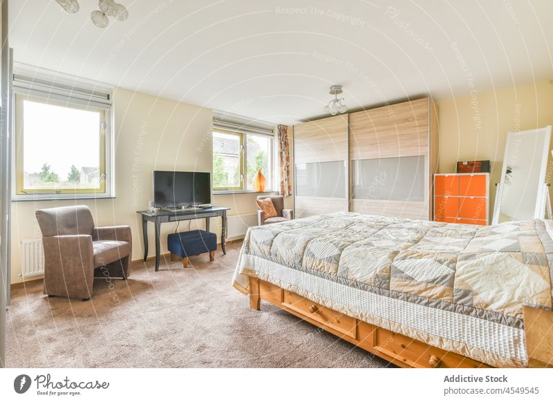 Schlafzimmer mit TV und Kleiderschrank Bett Design Innenbereich Stil heimisch modern FERNSEHER Armsessel Sitz Fenster wohnbedingt Decke Appartement flach