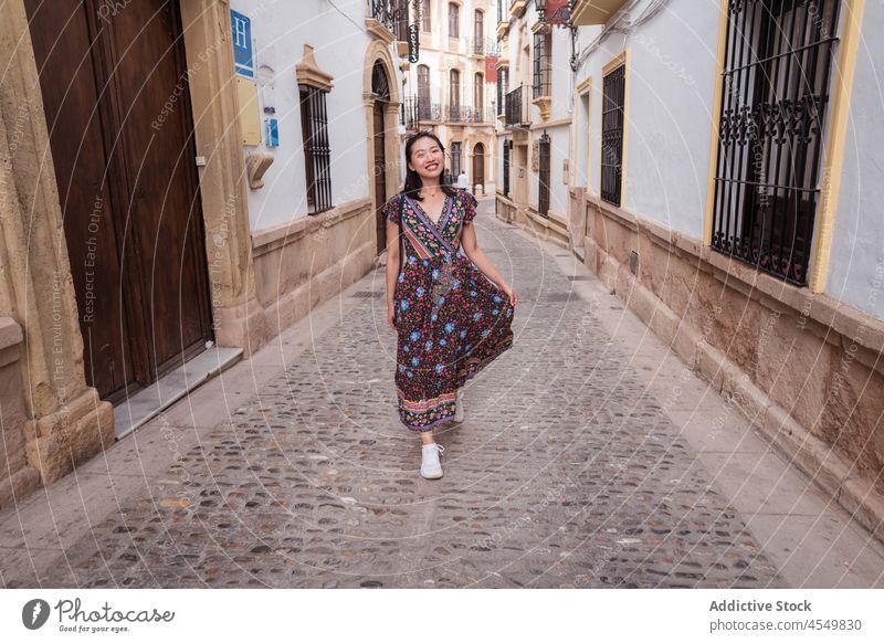 Lächelnde asiatische Frau zwischen alten Gebäuden Weg Stadt reisen gealtert Tourismus Straße Haus Architektur Sightseeing Tourist Fußweg pflastern wohnbedingt