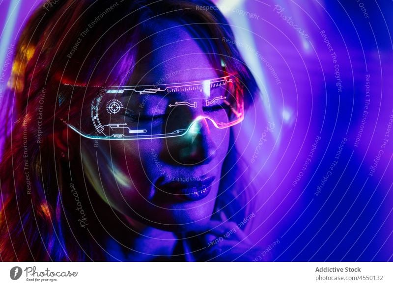 Frau in Neonlichtern mit Led-Brille futuristisch Metaversum Accessoire Augmented Reality Unschärfe Videospiel Kopfschuss hell modern Gerät Zeitgenosse cool