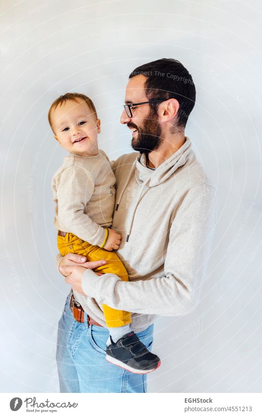 Junger Vater mit seinem Sohn in den Armen auf weißem Hintergrund. Vater und Baby Konzept. Beteiligung Papa Latein Glück Mann vereinzelt bezaubernd hispanisch