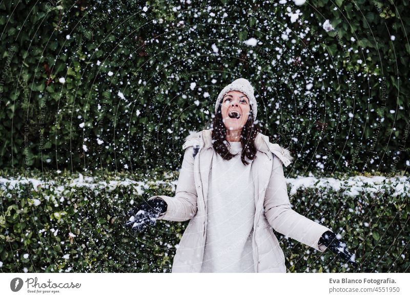 Fröhliche kaukasische junge Frau, die im Freien mit Schnee und Schneeflocken spielt, Spaß und Winterleben Spielen Park Kaukasier Berge u. Gebirge Schneefall